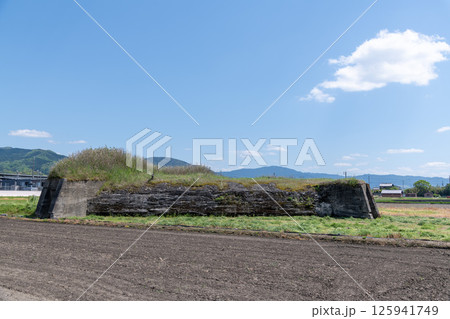 田植え前の水田地帯に佇む旧日本軍の柳本飛行場跡の北側防空壕跡 125941749