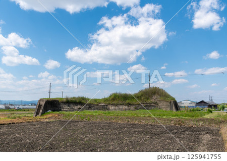 田植え前の水田地帯に佇む旧日本軍の柳本飛行場跡の北側防空壕跡 田植え前の水田地帯に佇む旧日本軍の柳本飛行場跡の北側防空壕跡 125941755
