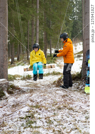 Joyful winter swing adventure in a snowy forest with laughter and warmth shared between friends during a crisp afternoon Joyful winter swing adventure in a snowy forest with laughter and warmth shared between friends during a crisp afternoon 125941827