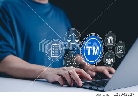 TM, Trademark and intellectual property protection concept. Businessman working on laptop with virtual icons representing trademarks, intellectual property rights, legal scales, security, innovation, 125942227