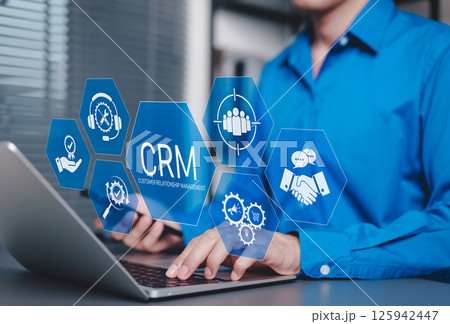CRM Customer Relationship Management Concept. Businessman using laptop with CRM icons representing customer support, service, relationship building, sales, and marketing automation tools software. 125942447