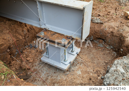 Concrete foundations support metal columns Concrete foundations support metal columns 125942540