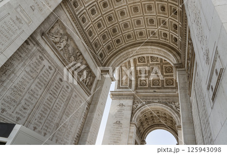 Stunning details view of ornate stone carvings under the arch of the famous Arc de Triomphe. 125943098