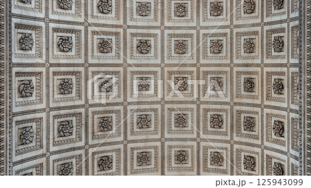 Upward View to the ornate stone carvings ceiling centre inside of the famous Arc de Triomphe. 125943099