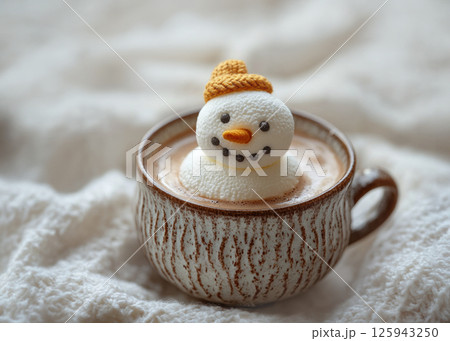Marshmallow snowman with carrot nose floating in cup of hot chocolate, cappuccino, chocolate drink, with candy canes, Christmas background, bokeh lights in the background 125943250