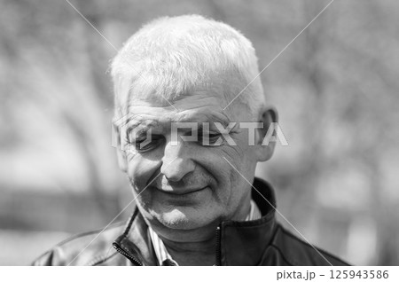 A well-dressed elderly man is smiling. A gray-haired man stands on the street. A well-dressed elderly man is smiling. A gray-haired man stands on the street. 125943586