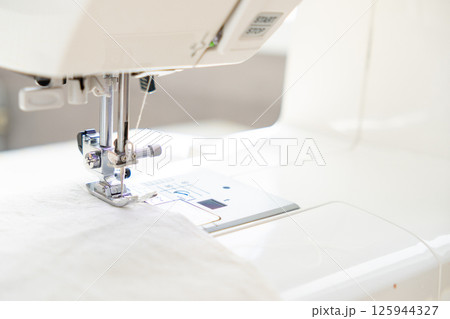 sewing machine with a cloth under a steel needle. manufacture of clothing. sewing machine with a cloth under a steel needle. manufacture of clothing. 125944327