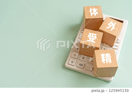 体外受精と書かれたブロックと電卓 体外受精と書かれたブロックと電卓 125945130