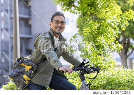 笑顔の自転車に乗った50代後半の男性 125945298
