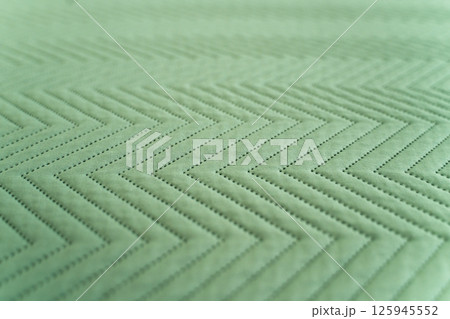 Detailed quilted green fabric with alternating zigzag geometric pattern 125945552