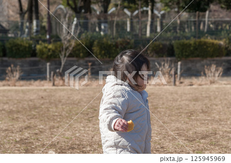 【相模原市立麻溝公園の芝生広場で遊ぶ1歳児】 125945969