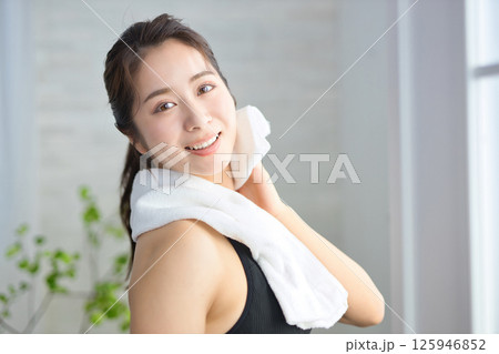 タオルで汗を拭くヨガウェアの20代女性 125946852