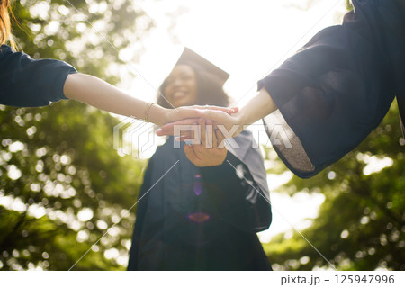 Group of students in graduation gown has an excited and delighted expression as they receive their diploma upon graduating from university. Diverse student feel proud about academic achievement. Group of students in graduation gown has an excited and delighted expression as they receive their diploma upon graduating from university. Diverse student feel proud about academic achievement. 125947996