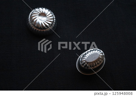 手紡ぎ藍染布の上の二つの丸トレー横構図 125948008