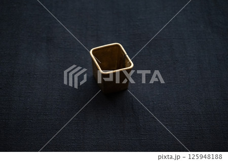 手紡ぎ藍染布の上のアンティーククッキー型横構図 125948188