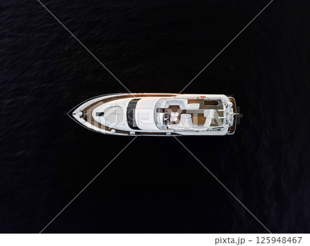 Experience the Luxurious Yacht Aglow, Radiating Elegance on the Dark, Serene Waters 125948467