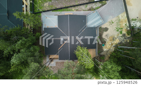 Aerial View of a Stylish, Modern House Elegantly Nestled Among a Lush Forest Landscape Aerial View of a Stylish, Modern House Elegantly Nestled Among a Lush Forest Landscape 125948526