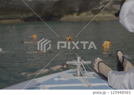 Enjoy a soothing and relaxing boat trip with swimmers in the clear, inviting waters Enjoy a soothing and relaxing boat trip with swimmers in the clear, inviting waters 125948563