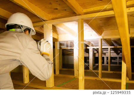 住宅の屋根裏で業務にあたる業者 住宅の屋根裏で業務にあたる業者 125949335