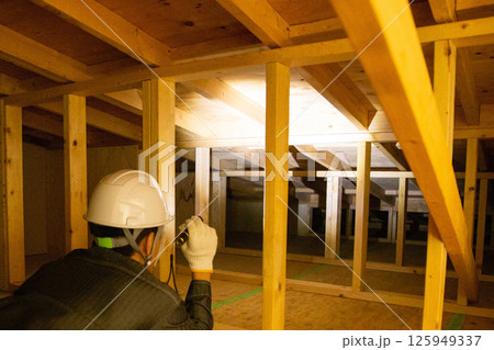 住宅の屋根裏で業務にあたる業者 住宅の屋根裏で業務にあたる業者 125949337