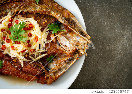 Fried Sea Bass Fish with Fish Sauce and Spicy Salad 125950747