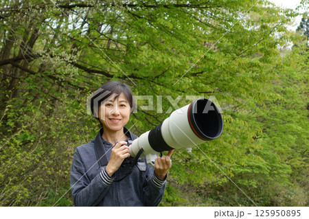望遠カメラを持つ笑顔の中年女性　カメラ目線 125950895
