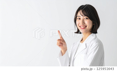 上を指さす白衣の若い女性 上を指さす白衣の若い女性 125951643