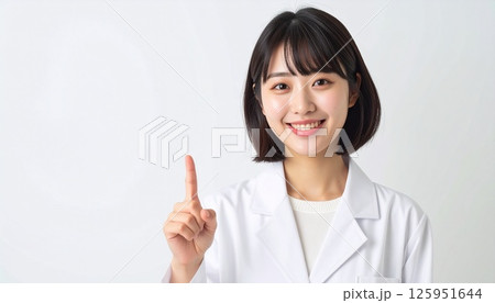 上を指さす白衣の若い女性 上を指さす白衣の若い女性 125951644