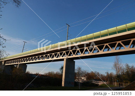 A bridge with a green railing and a train crossing it 125951853