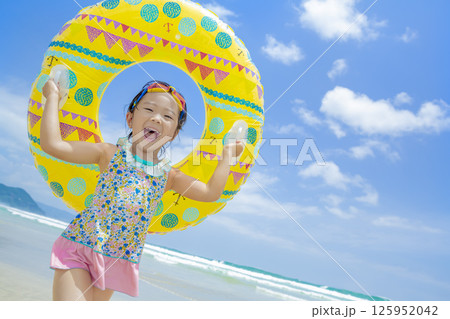 夏の海で浮き輪を持って遊ぶ女の子 夏の海で浮き輪を持って遊ぶ女の子 125952042