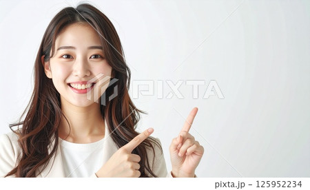上を指さすスーツを着た笑顔な女性 上を指さすスーツを着た笑顔な女性 125952234