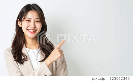 笑顔で指差しをするビジネスウーマン 笑顔で指差しをするビジネスウーマン 125952349