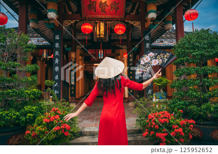 Back of a female tourist traveler in a Vietnamese cone hat Non La at Buddhist temple in Vietnam in Asia Back of a female tourist traveler in a Vietnamese cone hat Non La at Buddhist temple in Vietnam in Asia 125952652