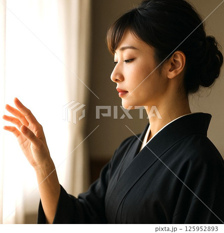 光に手を伸ばす横顔の女性 125952893
