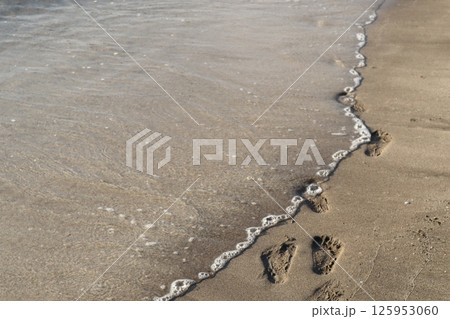 砂浜に残る足跡と海 125953060