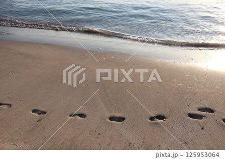 砂浜に残る足跡と海 125953064