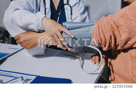 Nurse measuring blood pressure of elderly woman at table, closeup. Assisting senior generation 125953566