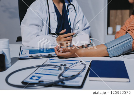 Nurse measuring blood pressure of elderly woman at table, closeup. Assisting senior generation 125953576