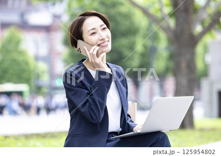 ビジネス　スマホ　通話をしているミドル女性 125954802