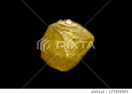 Natural rough yellow diamond crystal on dark background Natural rough yellow diamond crystal on dark background 125956061