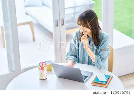 自宅でパソコンを操作する若い女性 125956792