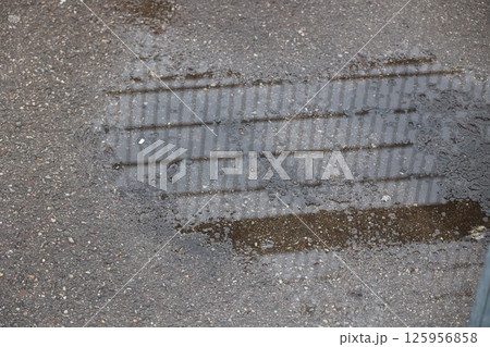 A puddle of water on a sidewalk 125956858