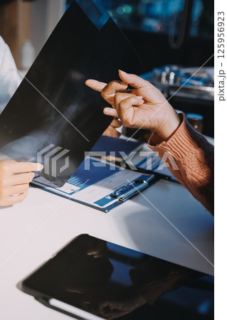 The doctor explain the old lady in retired life patient on lungs x-ray film and discuss treatment method to patient in hospital nursing home aged care by using health and life insurance planning 125956923