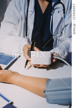 Nurse measuring blood pressure of elderly woman at table, closeup. Assisting senior generation 125956957