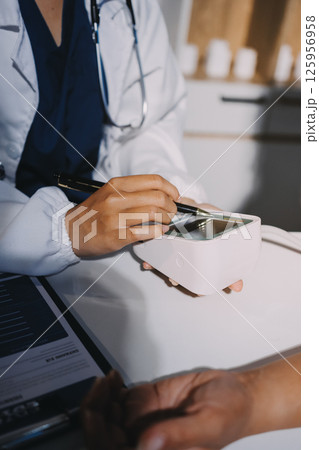 Nurse measuring blood pressure of elderly woman at table, closeup. Assisting senior generation 125956958