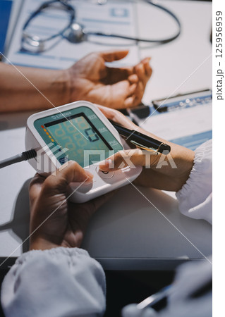 Nurse measuring blood pressure of elderly woman at table, closeup. Assisting senior generation 125956959