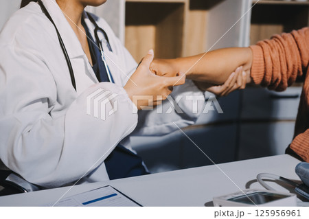Orthopedist examining patient in hospital 125956961