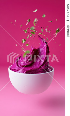 Purple dairy product splashing dynamically, garnished with fresh herbs against vivid pink background, highlighting culinary vibrancy and texture for marketing purposes 125957569