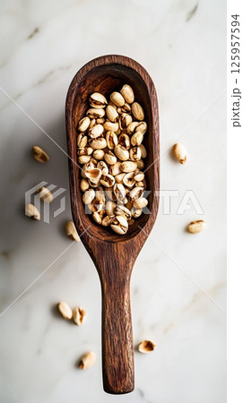 Close-up of raw fonio grains in wooden scoop with rustic kitchen background 125957594