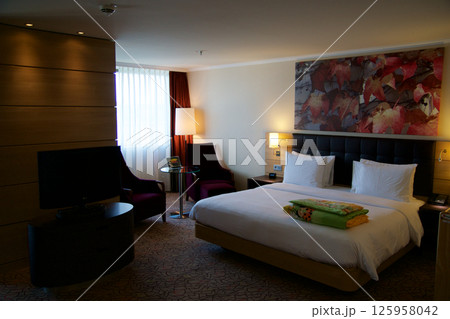 Mainz, Germany, July 8, 2017: Hotel Room with Double Bed and Red Lounge Chair 125958042